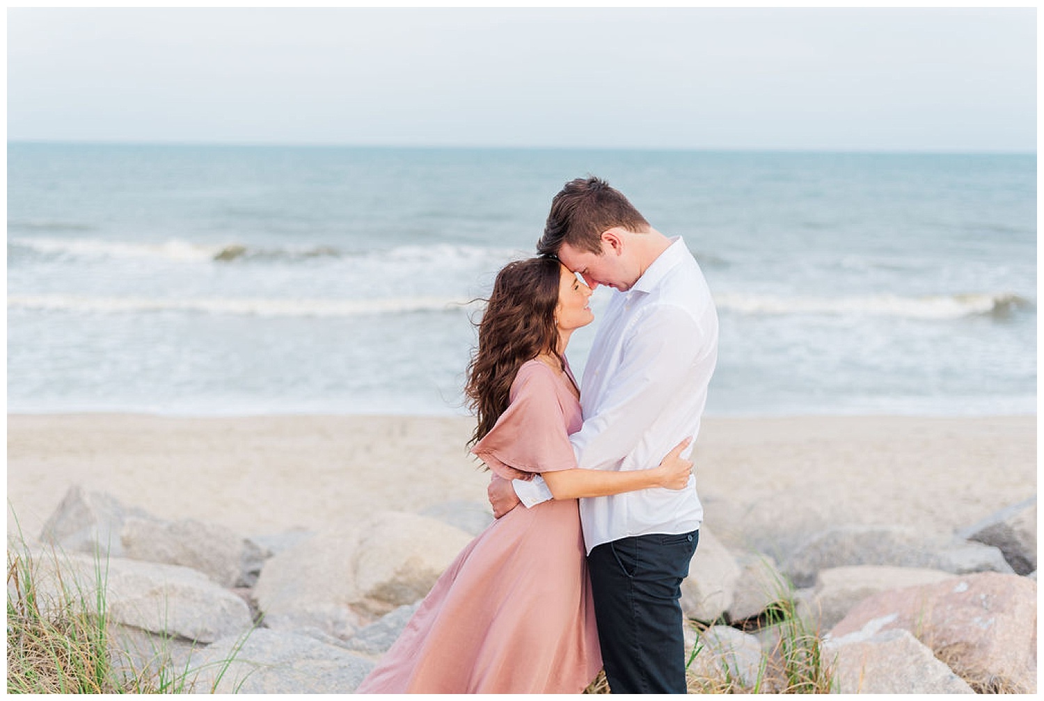 couple touching foreheads at engagement session at Kure Beach