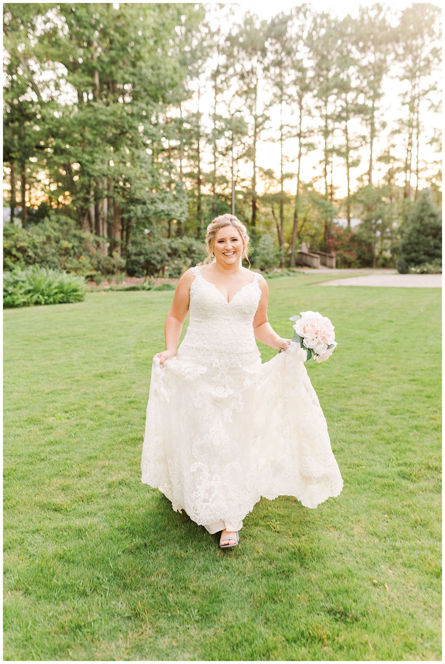 bride smiling and ho;ding wedding dress at North Carolina bridal session