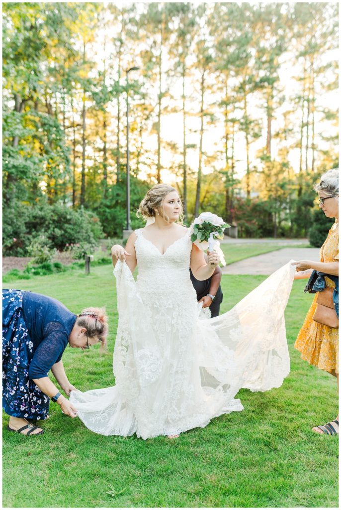 bride's friends adjusting her dress and veil at bridal session in North Carolina