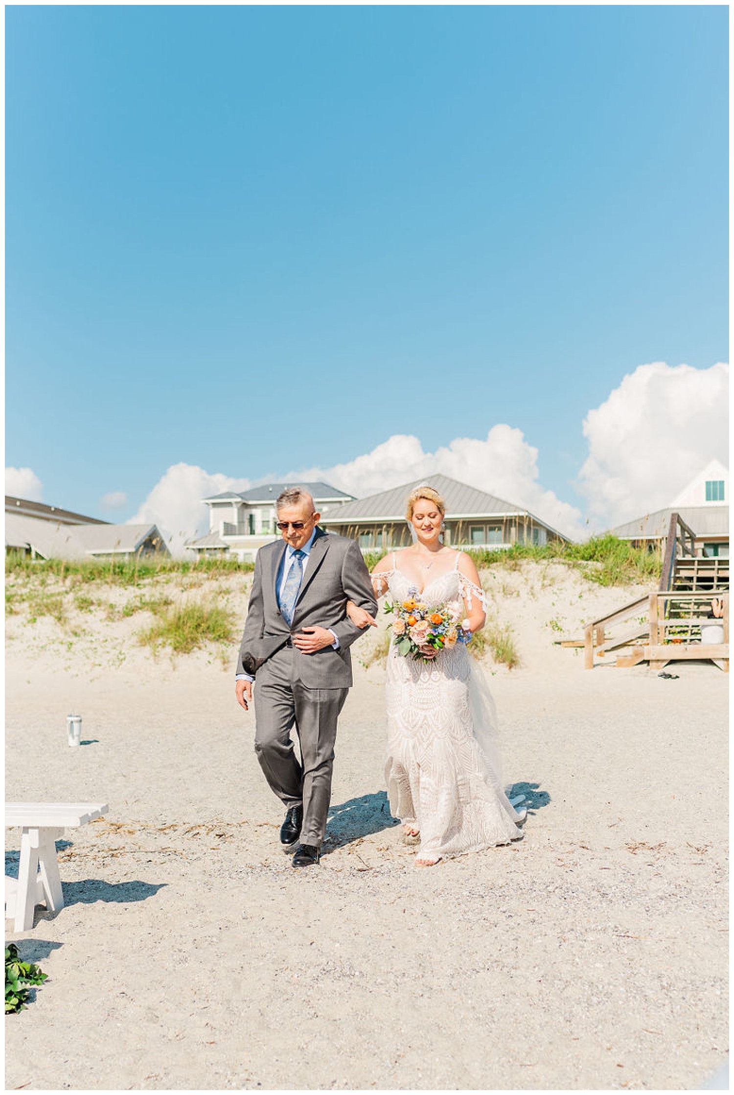 bride and bride's dad walking down the beach towards the wedding ceremony in North Carolina