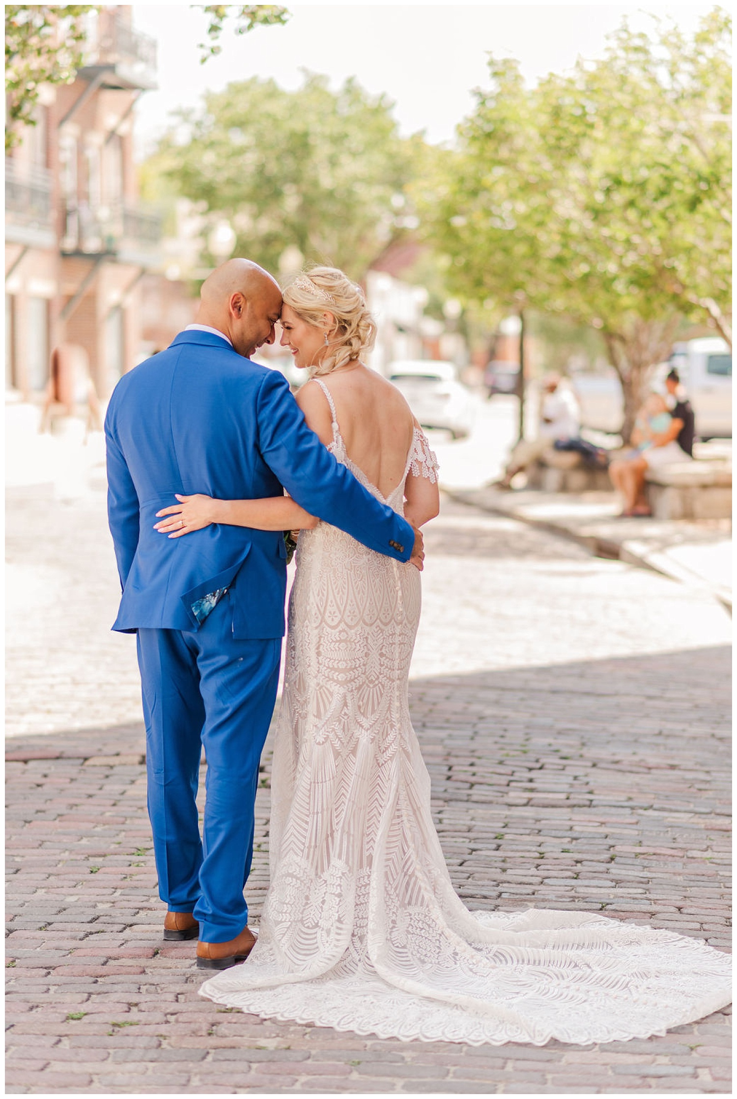 bride and groom standing together with their backs to the camera on the street in downtown Wilmington