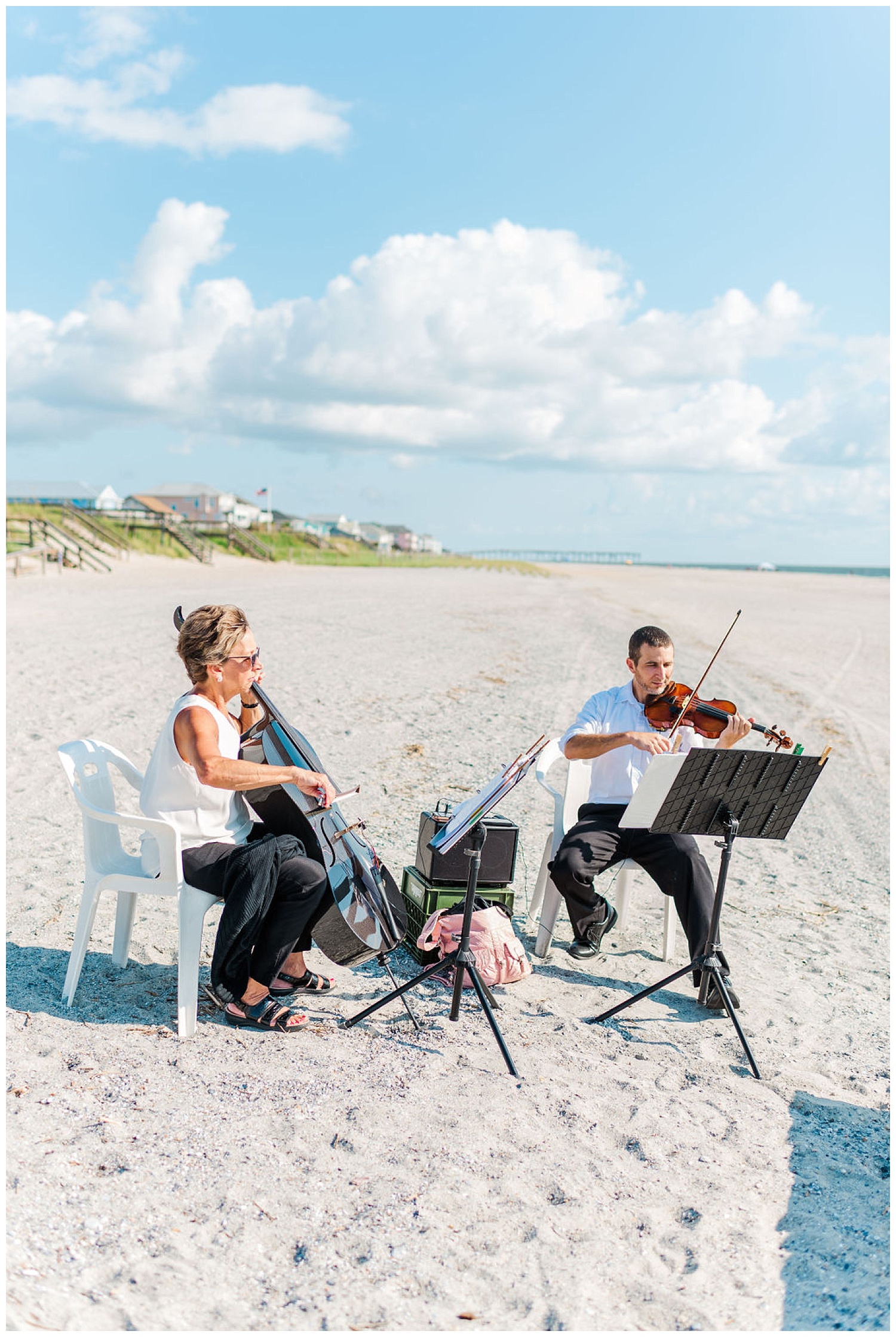 cellist and violinist playing on the beach for a wedding