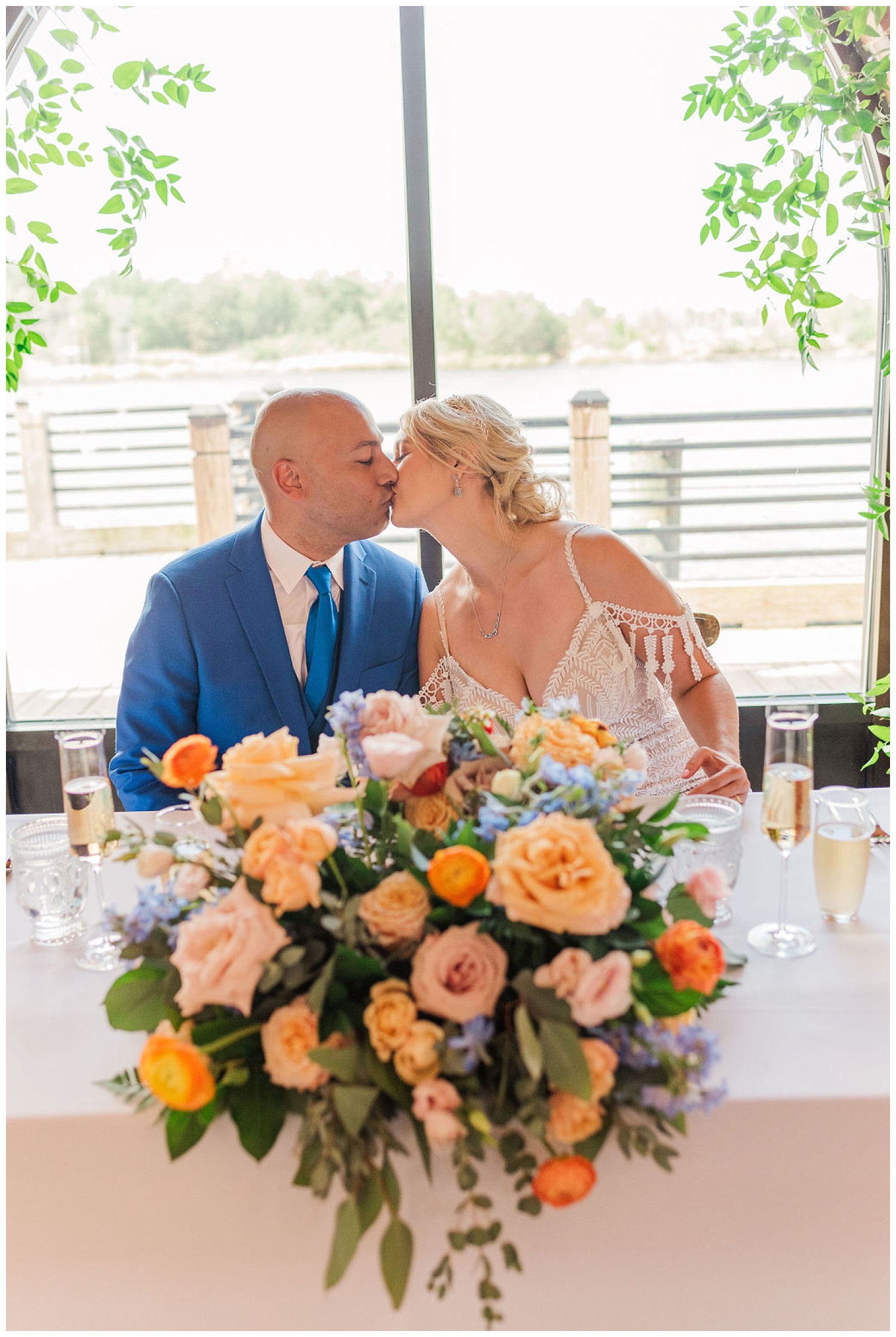 wedding couple kissing at their sweetheart table at the River Room