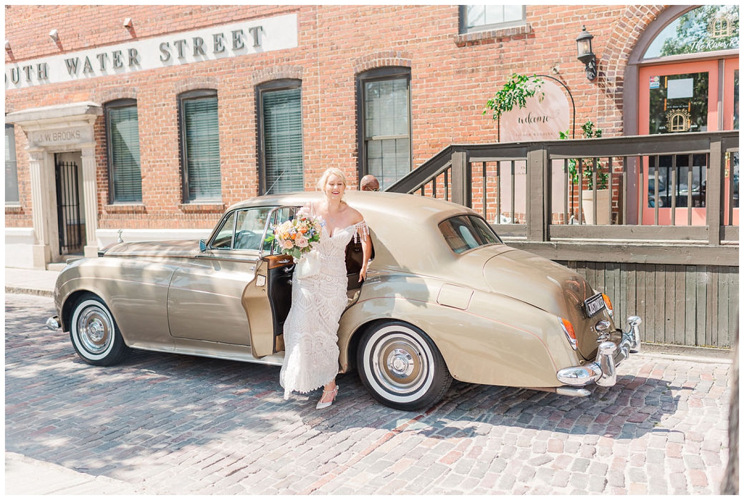 bride and groom stepping out of a cream colored Rolls Royce