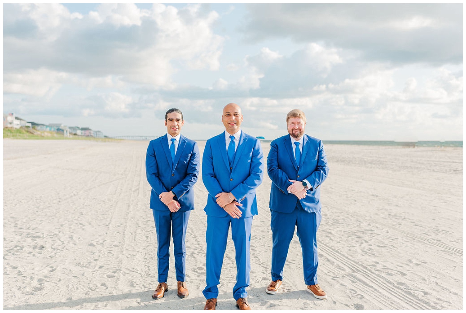 groom posing with his groomsmen on the beach