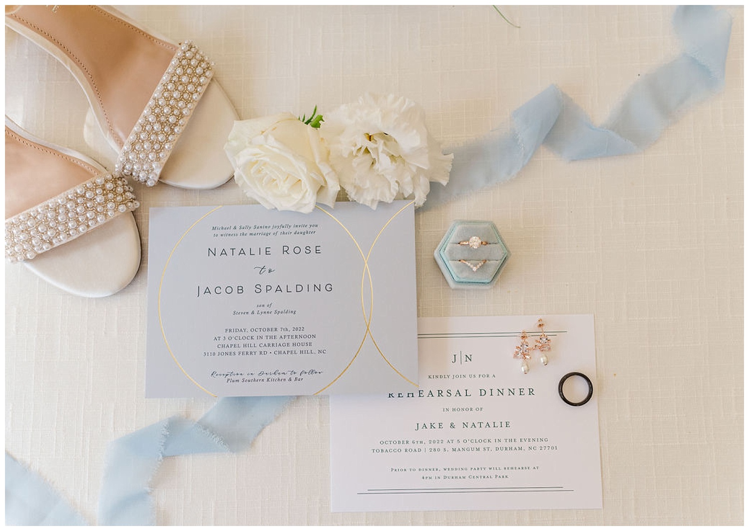 flat lay wedding details with ribbon and flowers