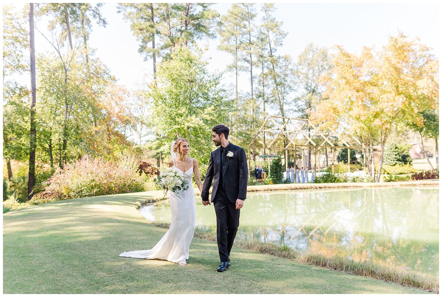wedding couple walking next to a pond at the Chapel Hill Carriage House
