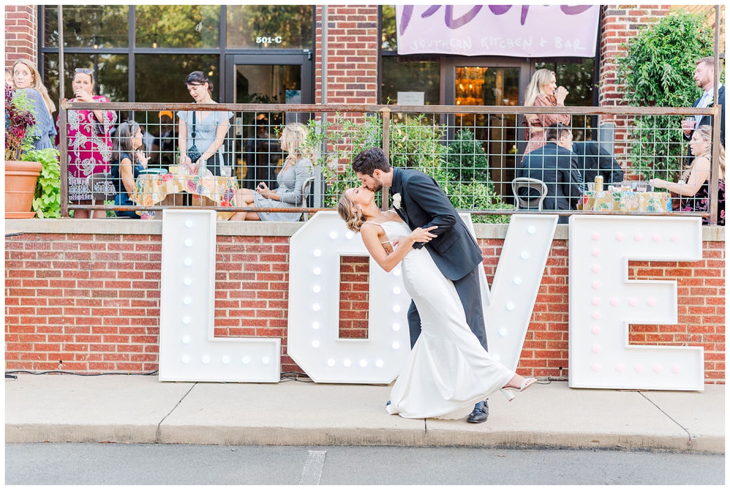 wedding couple dipping with a kiss outside the Plum Kitchen in Durham