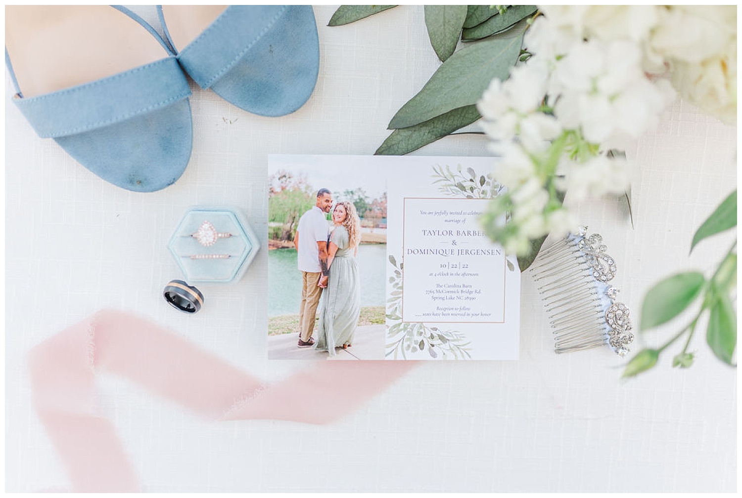 wedding invite sitting on top of pink ribbon next to blue shoes