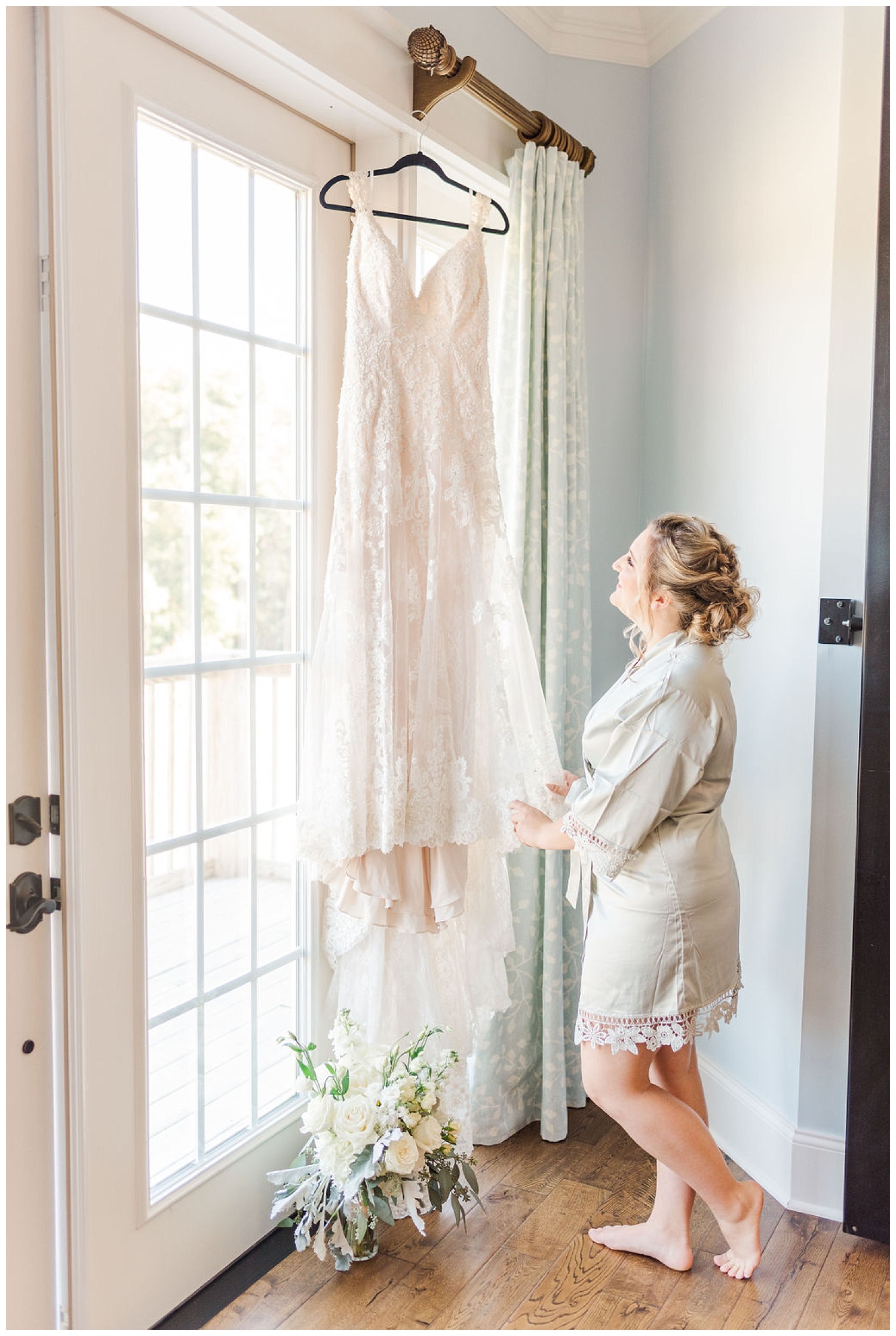 bride looking at dress hanging while getting ready