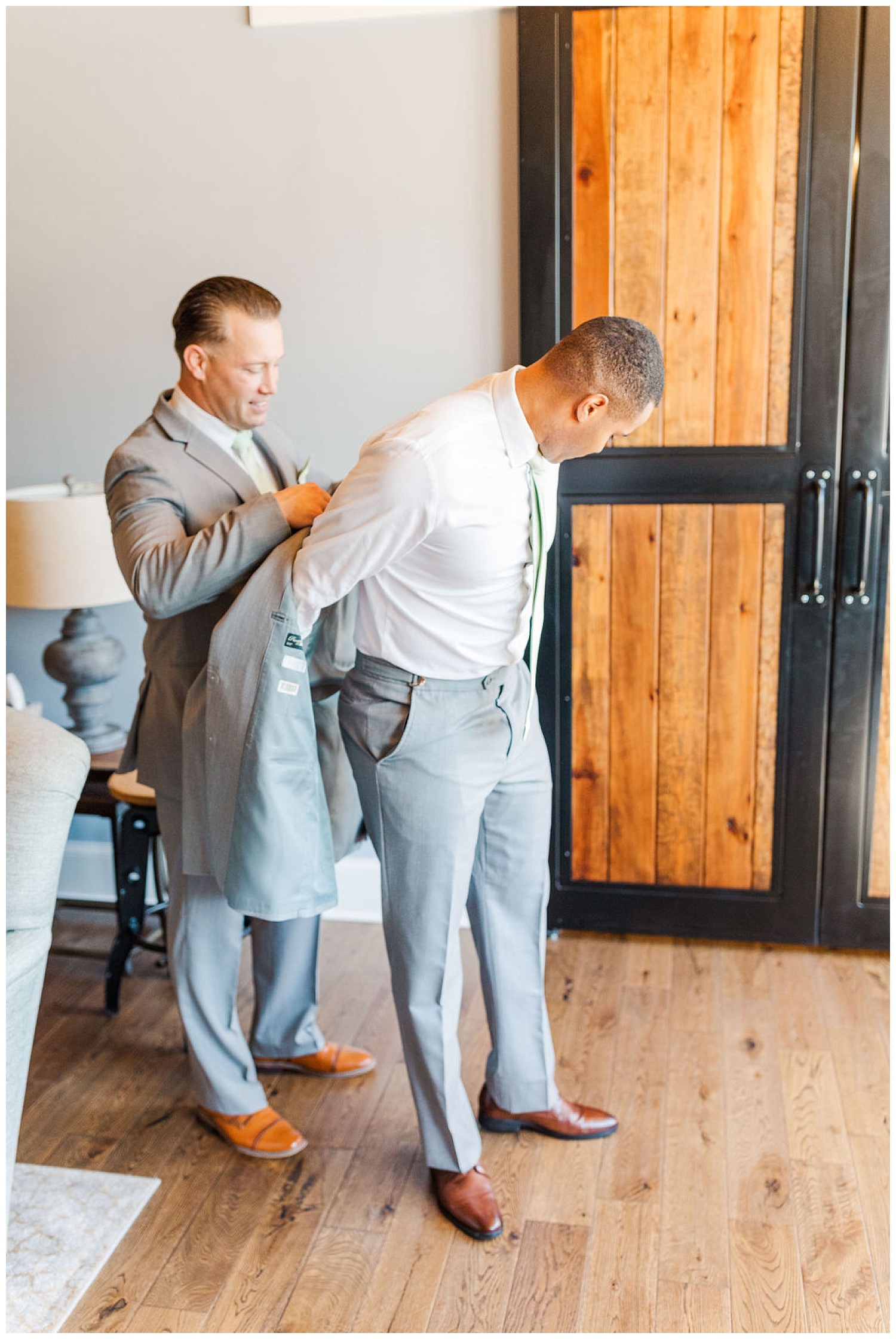 groom putting on his jacket while getting ready