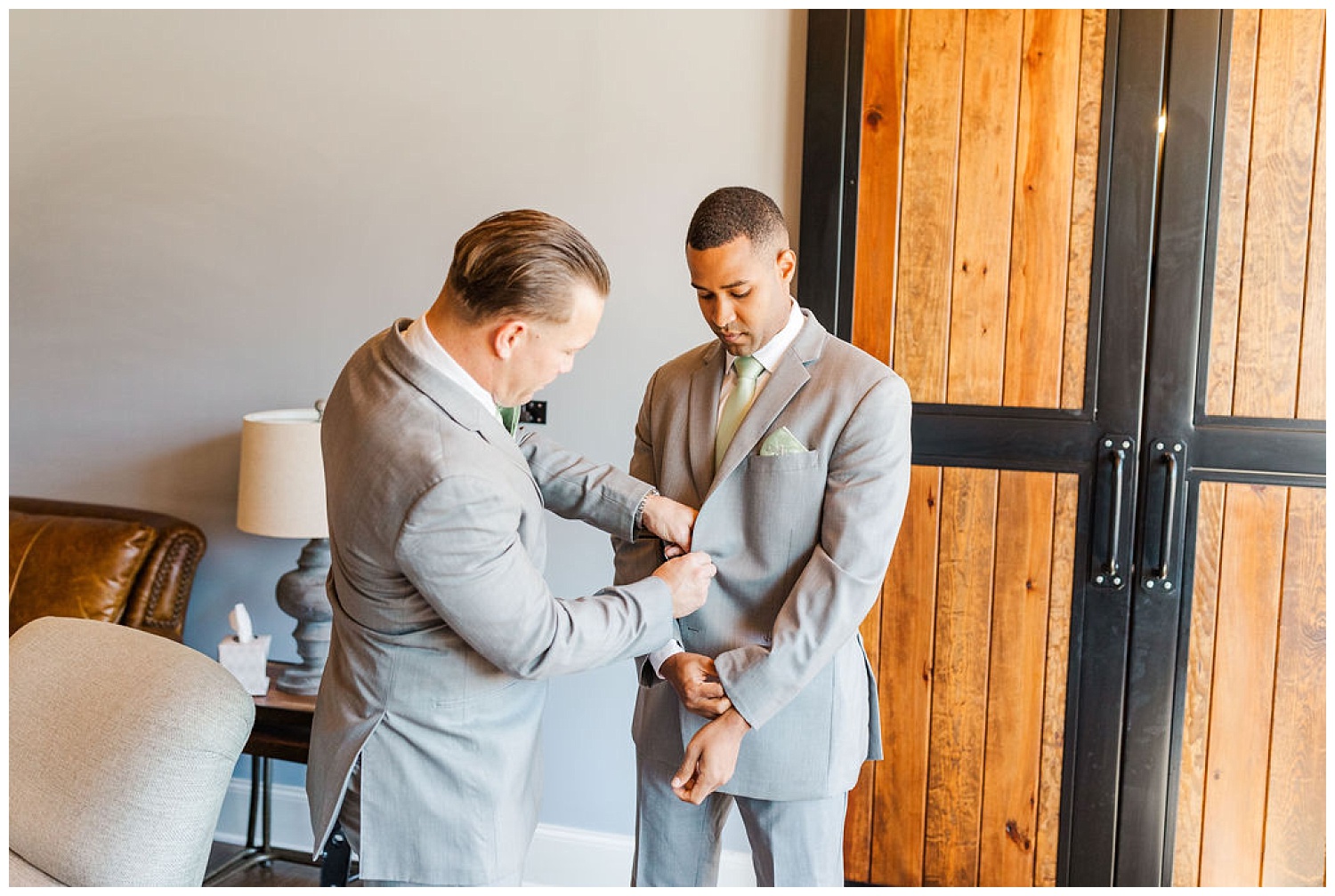 groom adjusting his jacket while getting ready at wedding