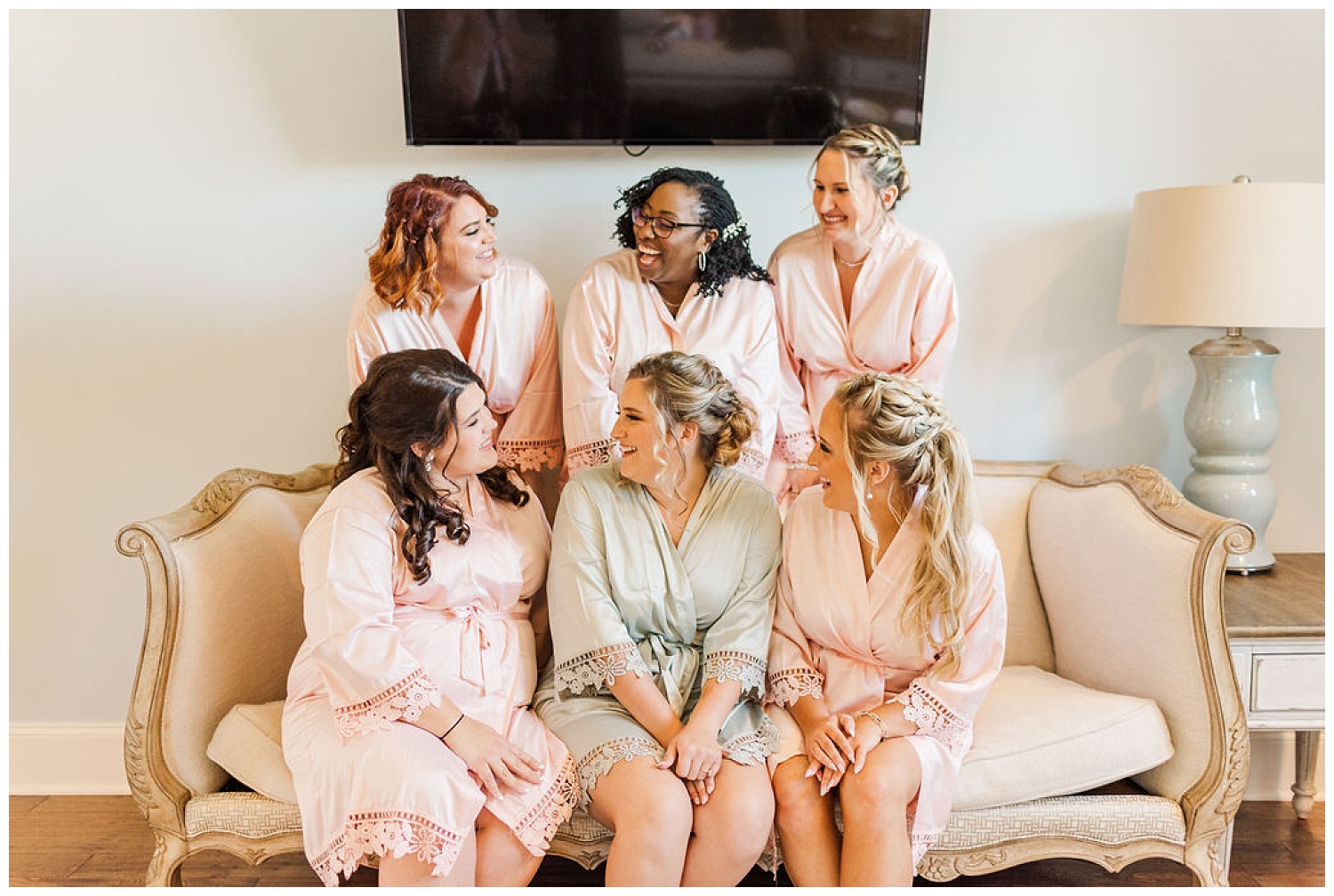 bride and bridesmaids laughing while getting ready