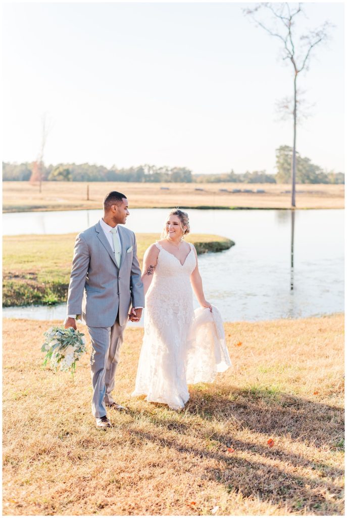 bride and groom portraits next to the pond at The Carolina Barn
