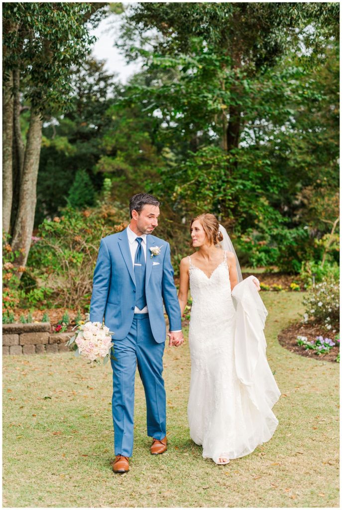 bride and groom walking together at New Hanover County Arboretum in Wilmington, NC