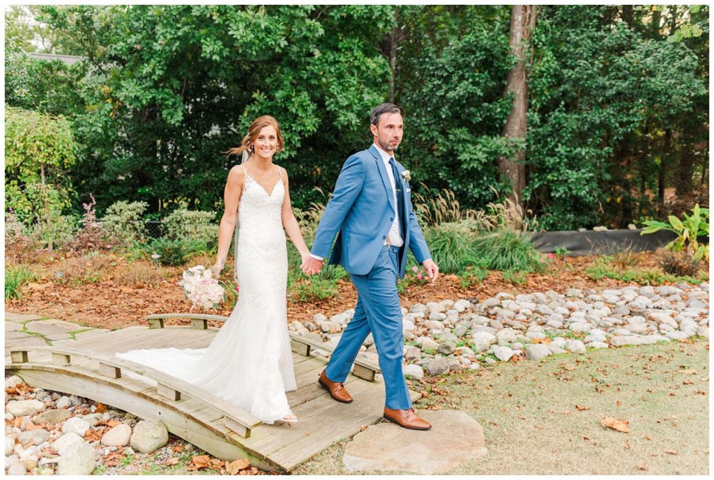 wedding couple walking on a bridge at New Hanover County Arboretum in Wilmington