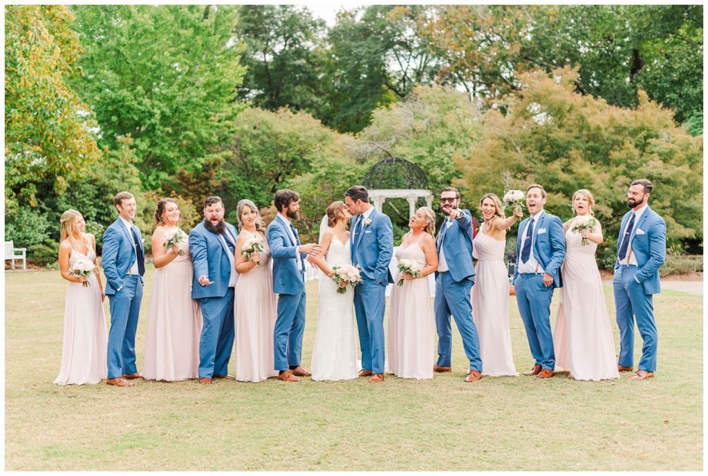 bride and groom kissing with full bridal party at New Hanover County Arboretum in NC