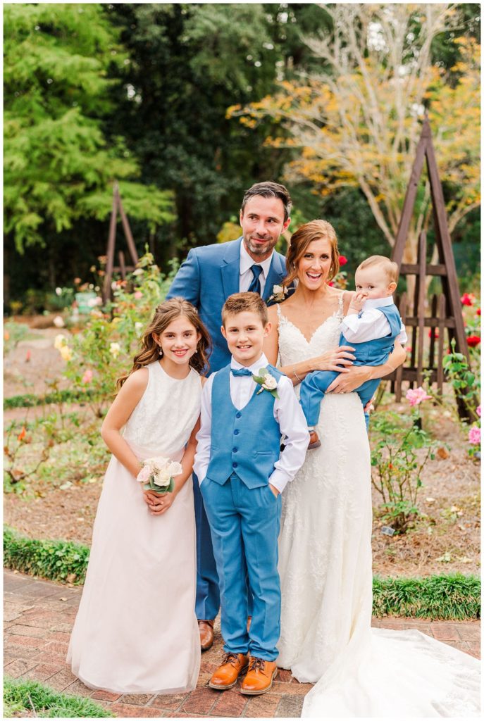 bride and groom posing with kids after wedding ceremony