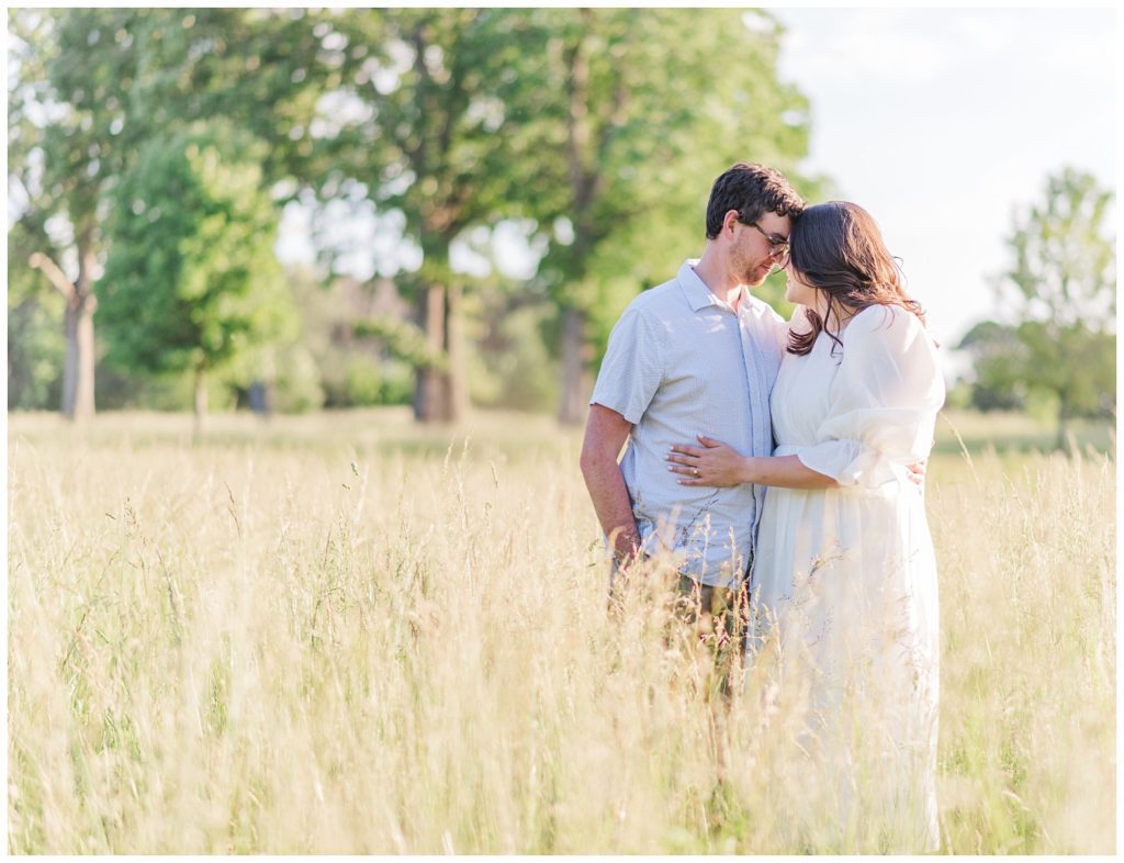 couple standing in a field for engagement photos in North Carolina