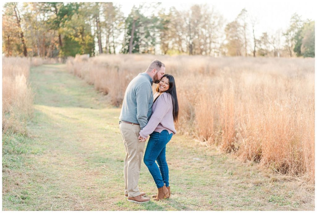 couple laughing in a field at Winston-Salem engagement session