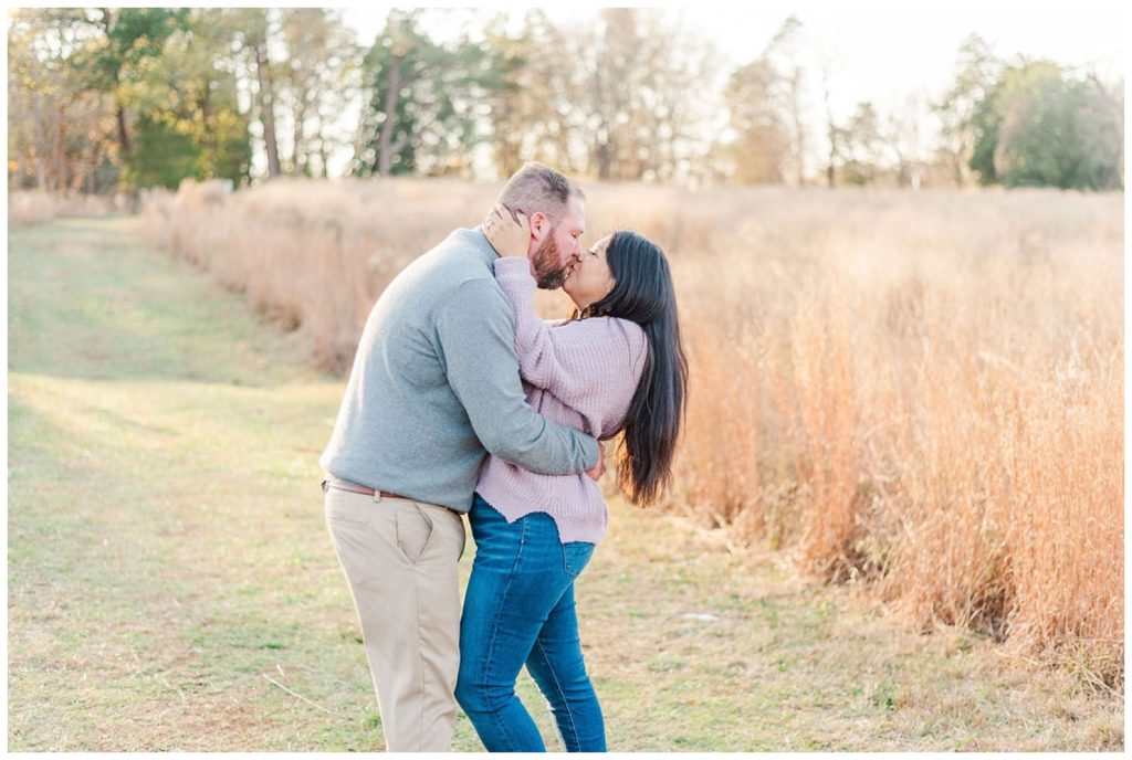 couple kissing in a field in Winston-Salem at Reynolda