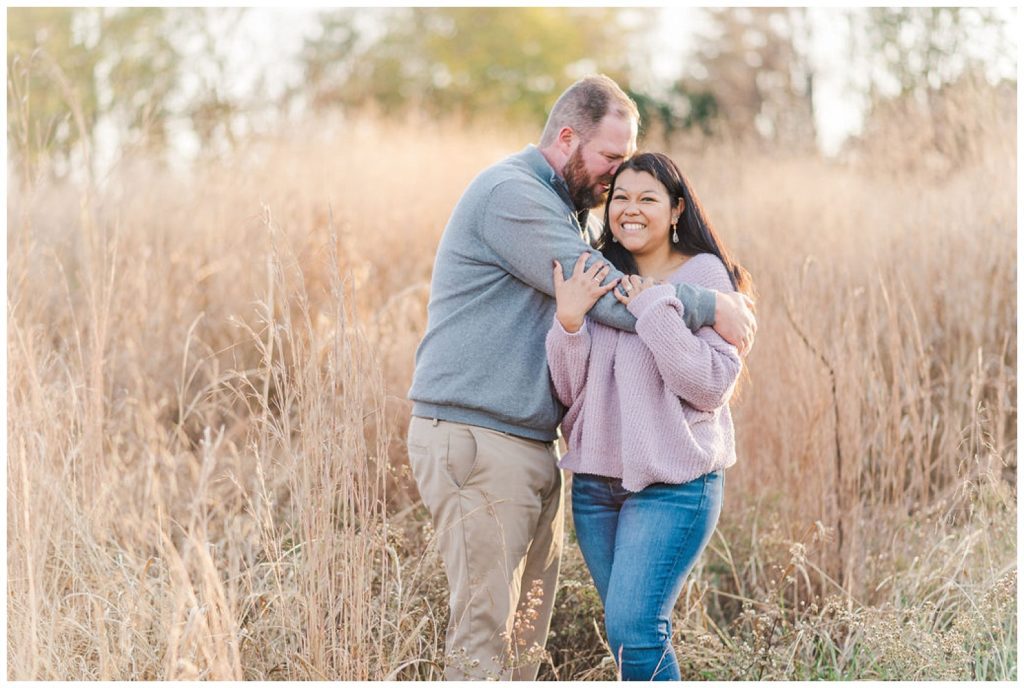engaged couple hugging in a wheat field in Winston-Salem in fall
