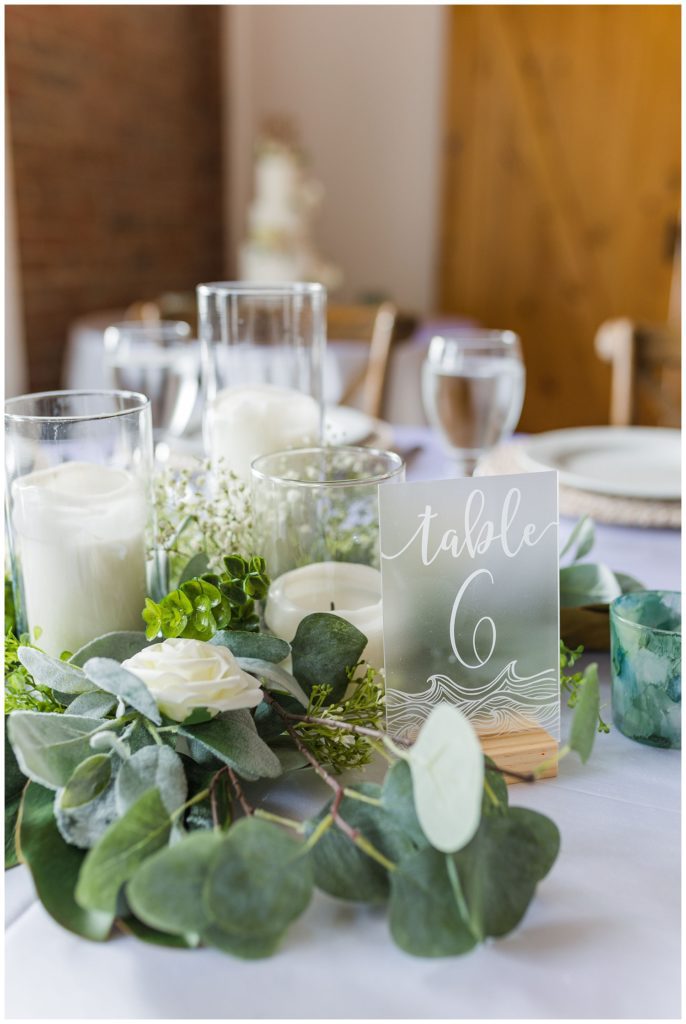 white candles and green and white florals set up by wedding planner Sarah Ann Events at the River Room