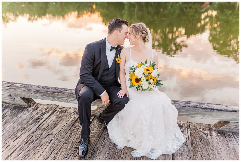 bride and groom touching noses on a dock in Wallace, N.C,