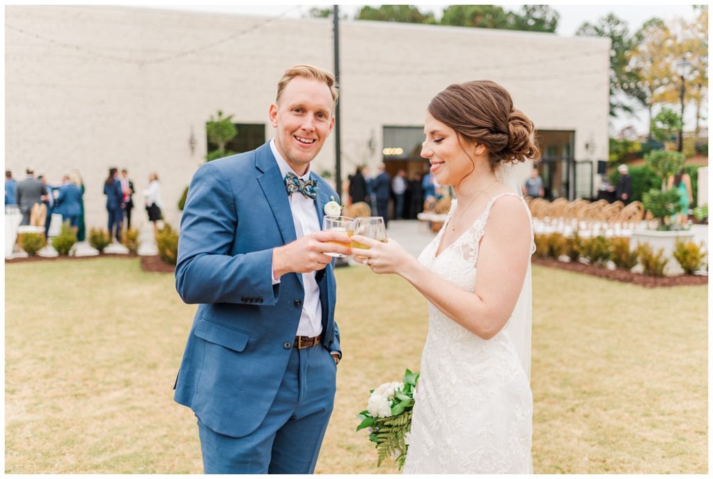 wedding couple toasting drinks on the lawn