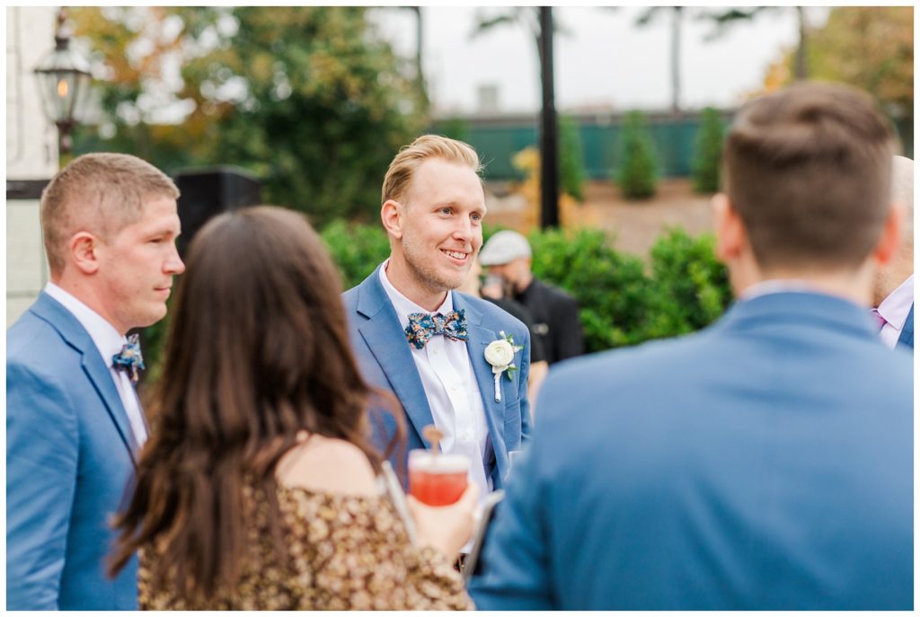 groom with guests at cocktail hour 