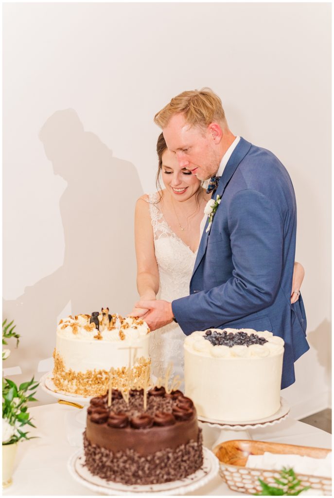 bride and groom cutting cake at fall wedding reception