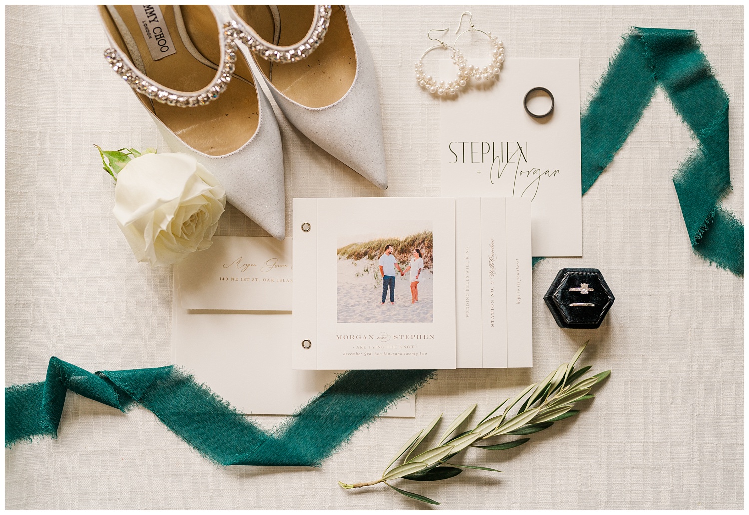 bridal details with invitation and green ribbon and wedding shoes
