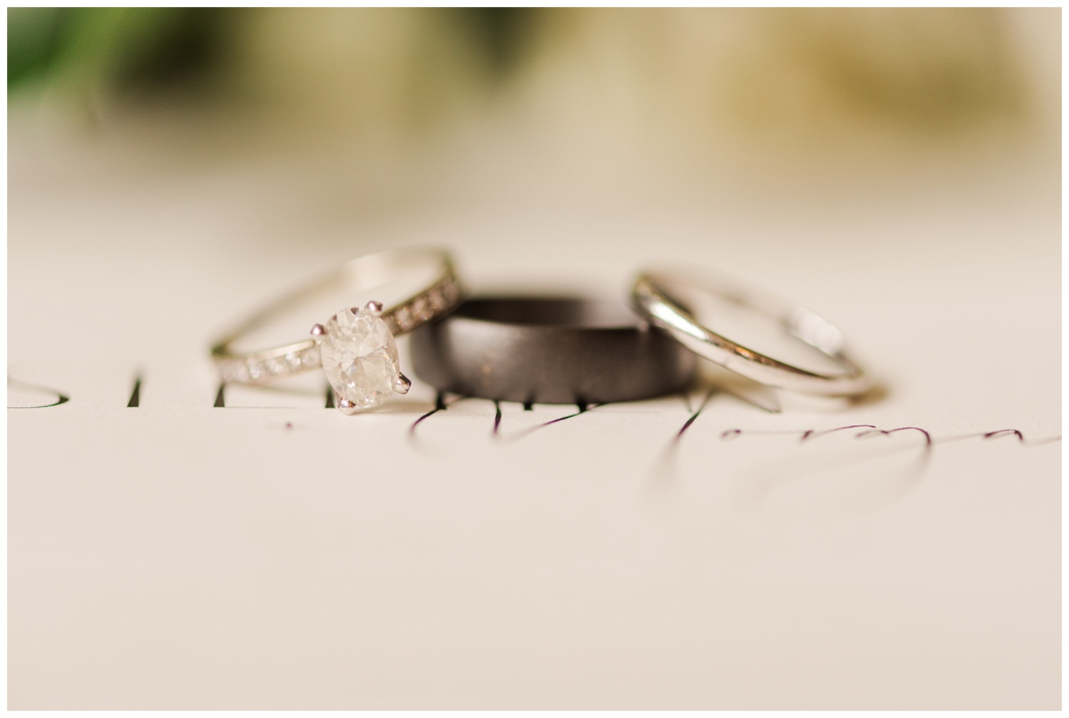 wedding rings on top of invitation at Wilmington wedding