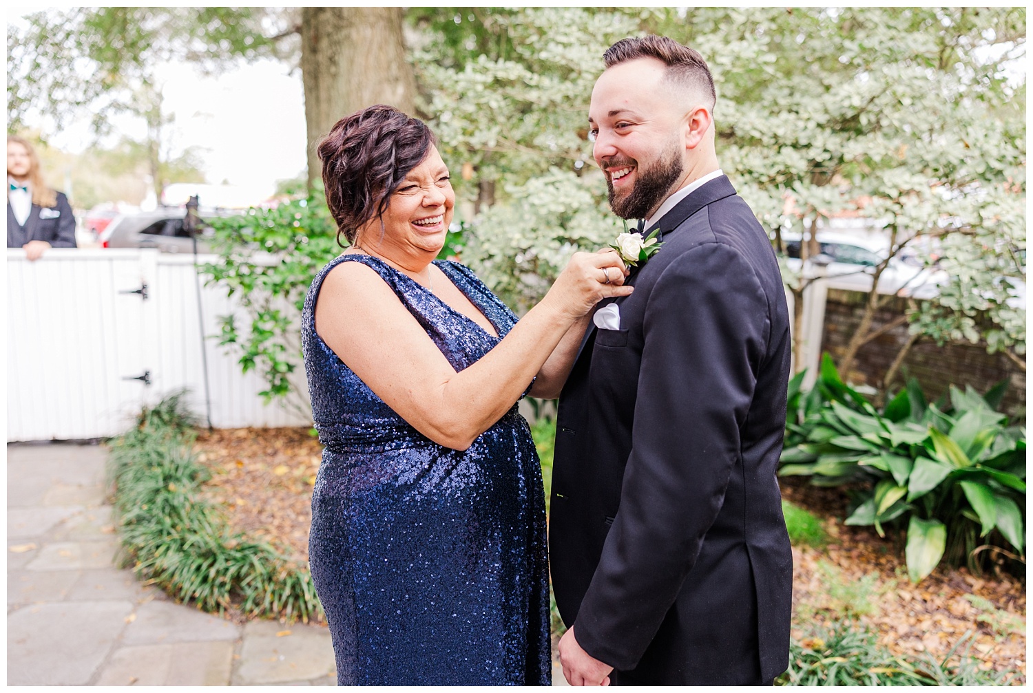 groom's mom pinning on his boutonniere before the wedding 