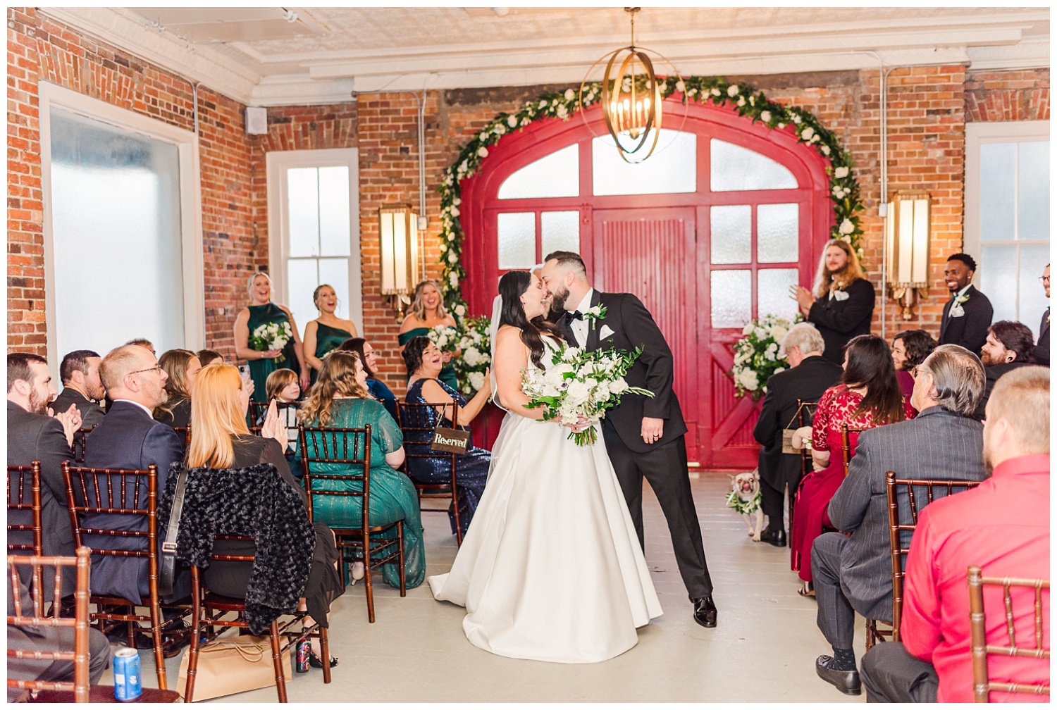 bride and groom kissing down the aisle at winter ceremony in Wilmington