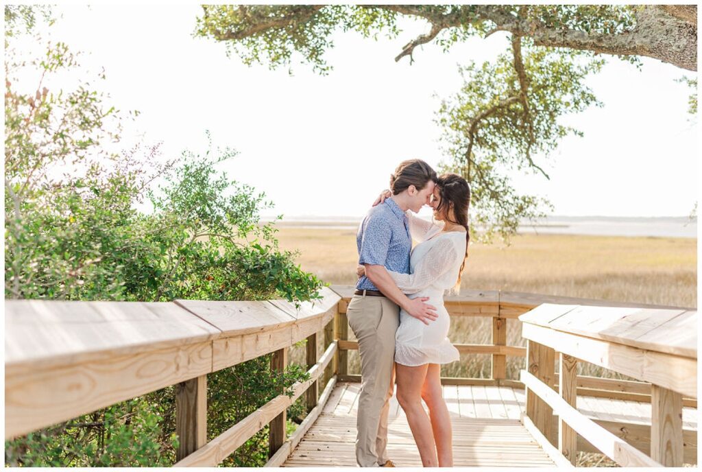 engaged couple standing on a boardwalk at Fort Fisher