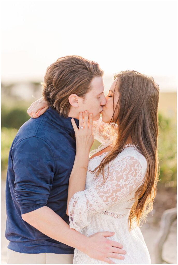 couple kissing at beach engagement session in North Carolina