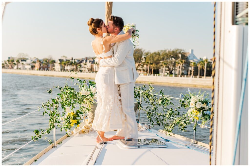 elopement couple kissing on a sailboat at Charleston styled shoot