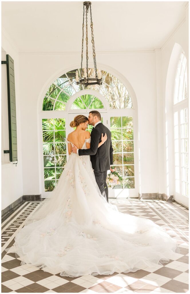 bride and groom posing inside the sun room at Lowndes Grove
