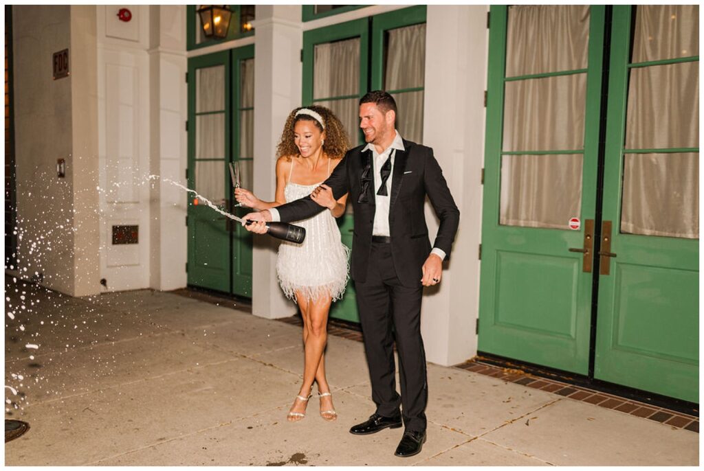 wedding couple popping champagne at night at Charleston styled shoot