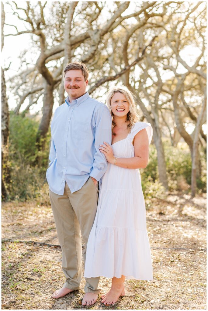 couple wearing white and blue for beach engagement session