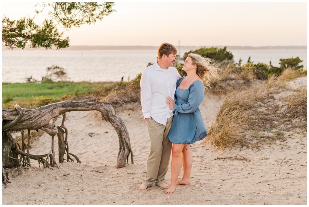 couple wearing blue and white at Fort Fisher beach engagement