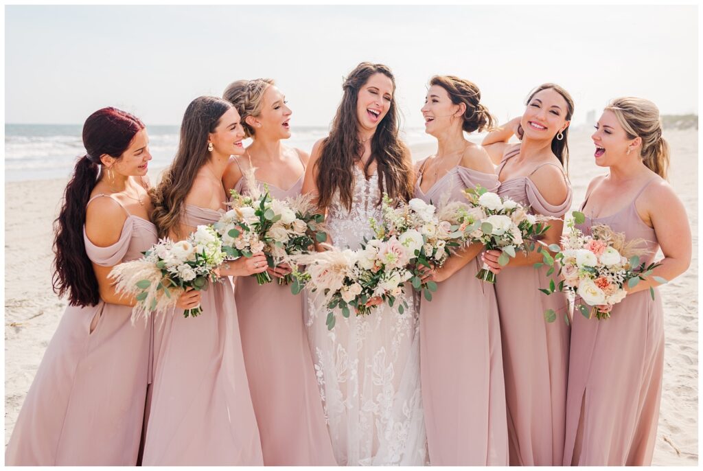 bridesmaids laughing on the sand at Ocean Isle wedding