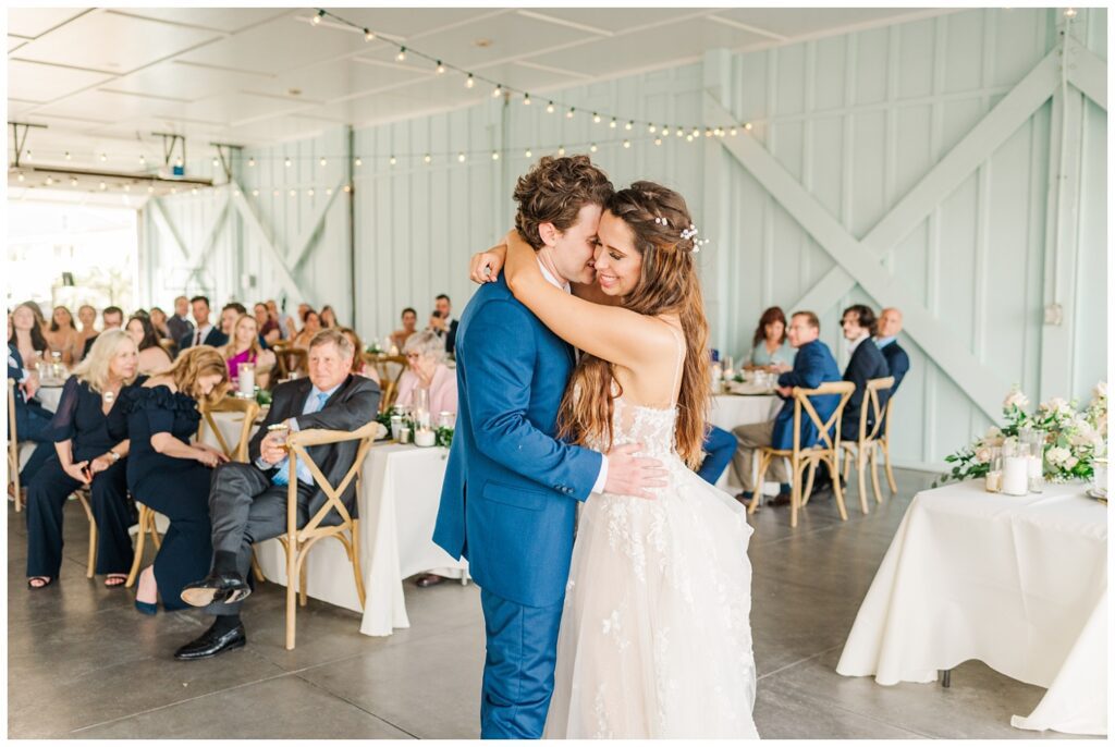 bride and groom have first dance at beach wedding reception