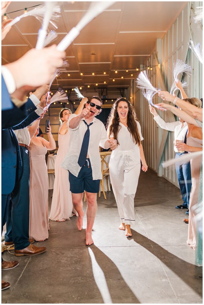 bride and groom walking at reception exit at beach wedding