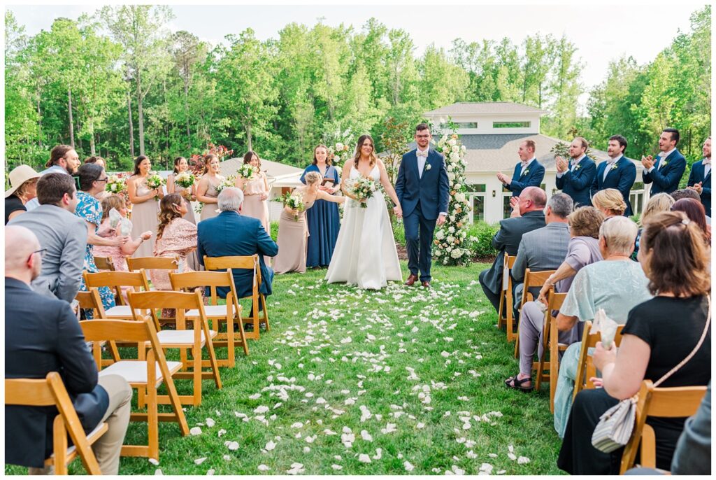 wedding couple walking back down the aisle in outdoor ceremony