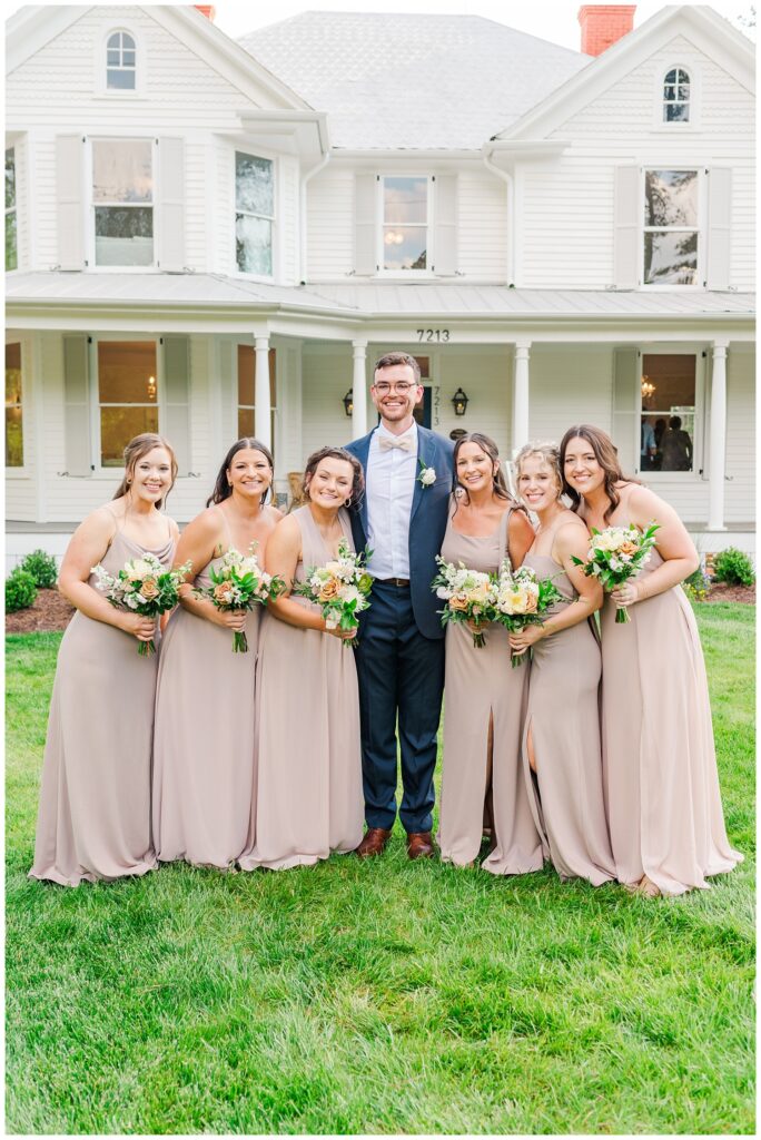 groom posing with bridesmaids at North Carolina wedding