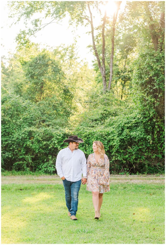 engagement couple walking on a farm in Fayetteville