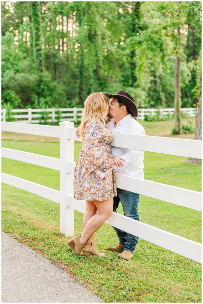 couple kissing over a white fence in Fayetteville