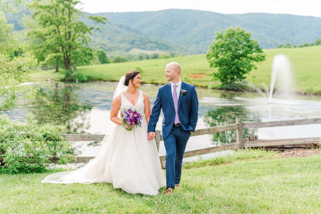 wedding couple walking next to a pond and fence at North Carolina venue